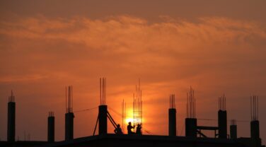 The sun is setting behind a tech construction site.
