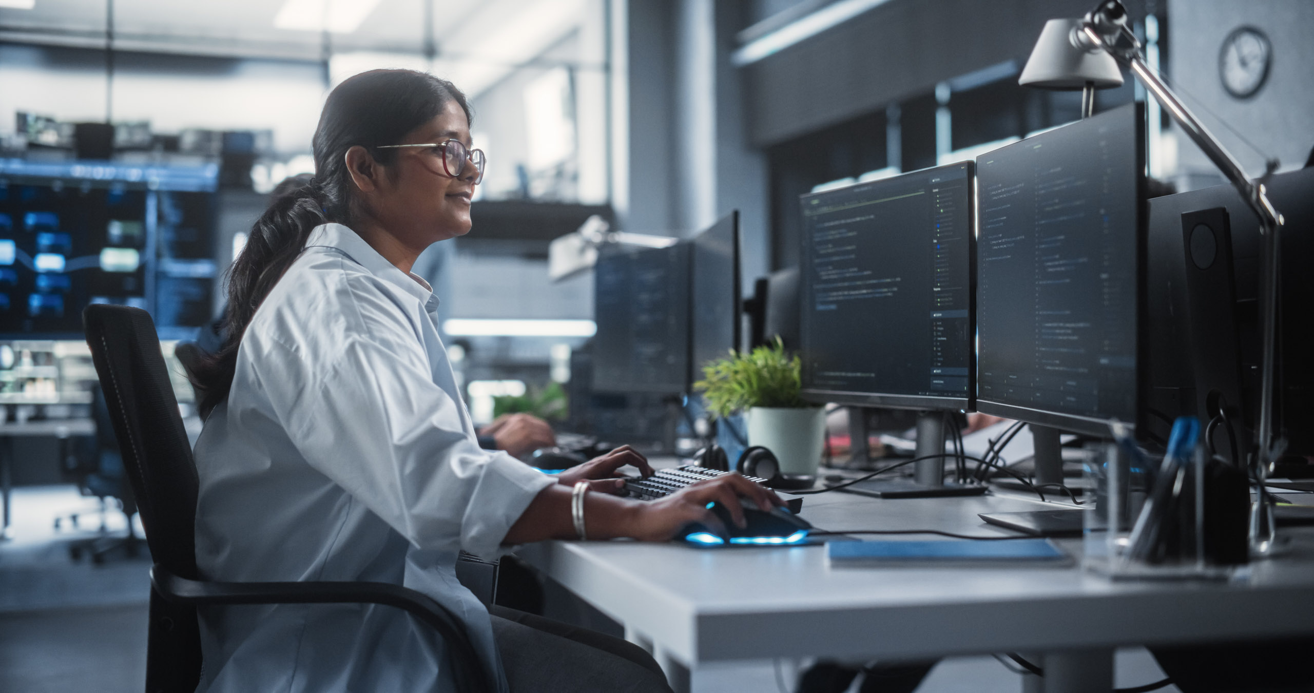 A strategic woman immersed in tech innovation while working at a computer in an office.